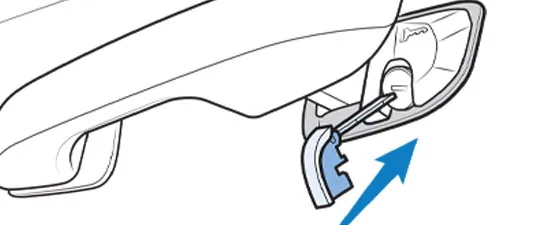 Honda close-up of a door handle end cap swung open on its tether, revealing the hidden key cylinder underneath